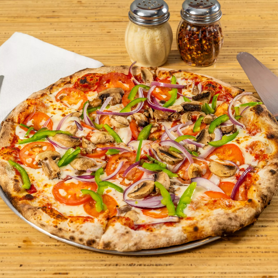 Bear Brick Oven Co's veggie pizza with tomatoes, mushrooms, green peppers, and red onions.